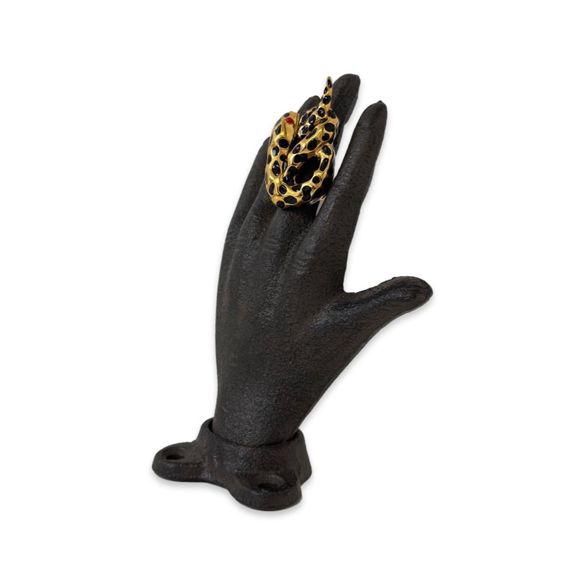 Black "Serpiente" Snake Ring on a black hand sculpture on a white background