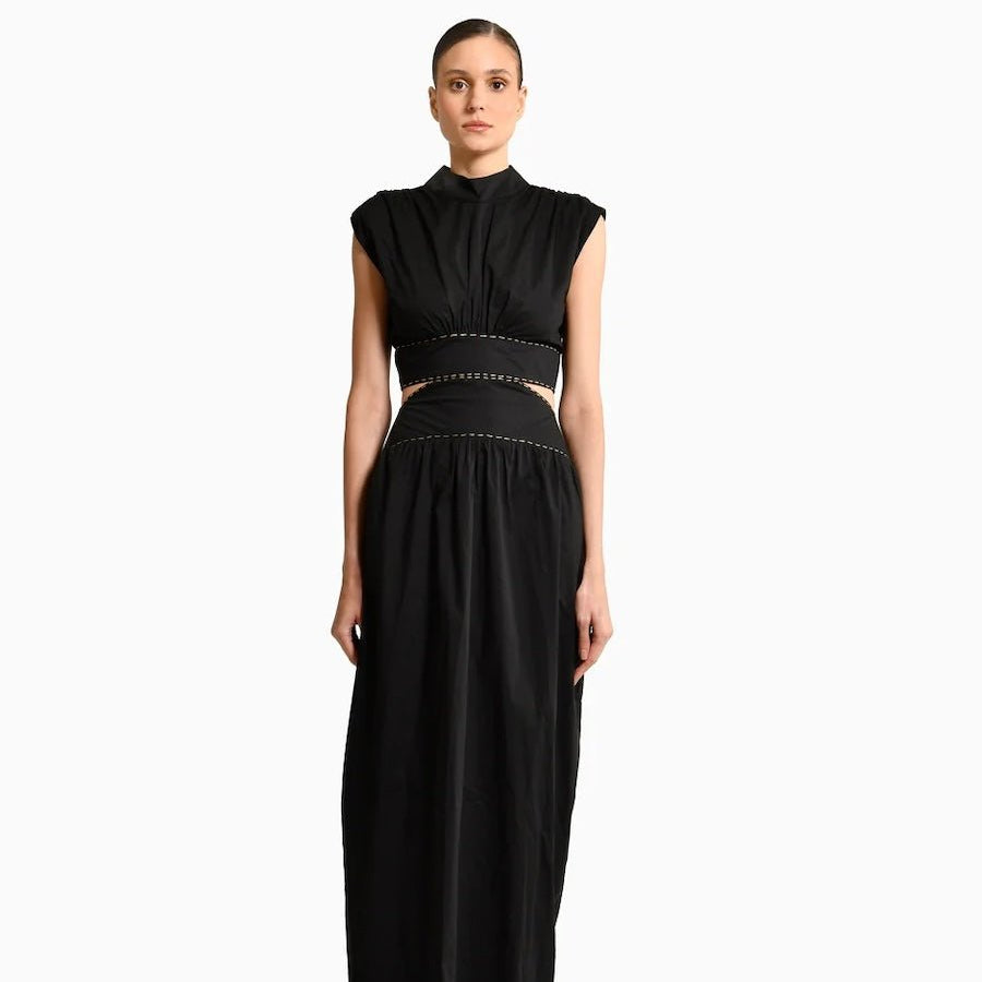 Model wearing Toya Maxi Dress with Side Cutouts, mockneck and gold stitching around waist on plain white background