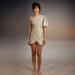 A model wearing Tutti Kalua Dress and standing on sand with an abstract background