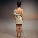 Back of model wearing Tutti Kalua Dress and standing on sand with an abstract background
