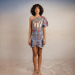Model wearing Tutti Pampa Dress, standing on sand with gradient background