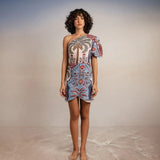 Model wearing Tutti Pampa Dress, standing on sand with gradient background