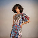Model posing with arm on her hip, wearing Tutti Pampa Dress, standing on sand with gradient background