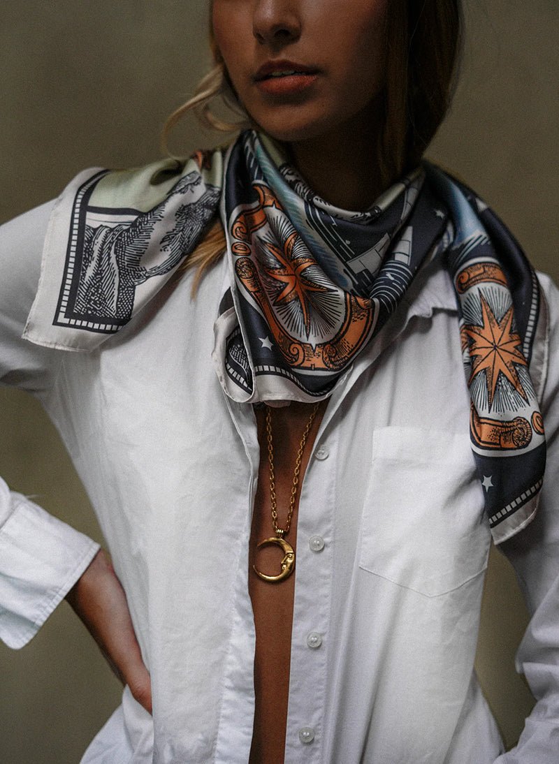 Model wearing the Zodiac Moon Scarf paired with a white longsleeve and a long moon necklace.