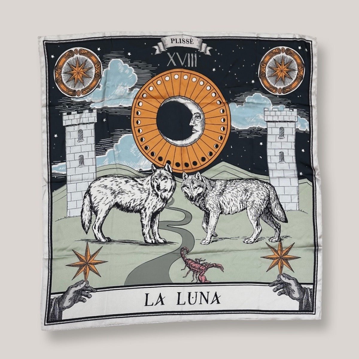 Zodiac Moon Scarf by Plissé. Image includes the night sky full of stars, towers, and playful elements like the wolves and stars. Scarf is pictured on white background.
