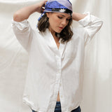 Model wearing white 3/4 sleeve top, blue jeans, wearing the Zodiac Scarf for Aquarius wrapped on head. She is standing on a plain white background.