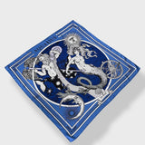 Zodiac Scarf for Aquarius by Plissé. Image of water bearer, mermaid, sun, moon, and the eliptic. The blue scarf is floating on a white background.