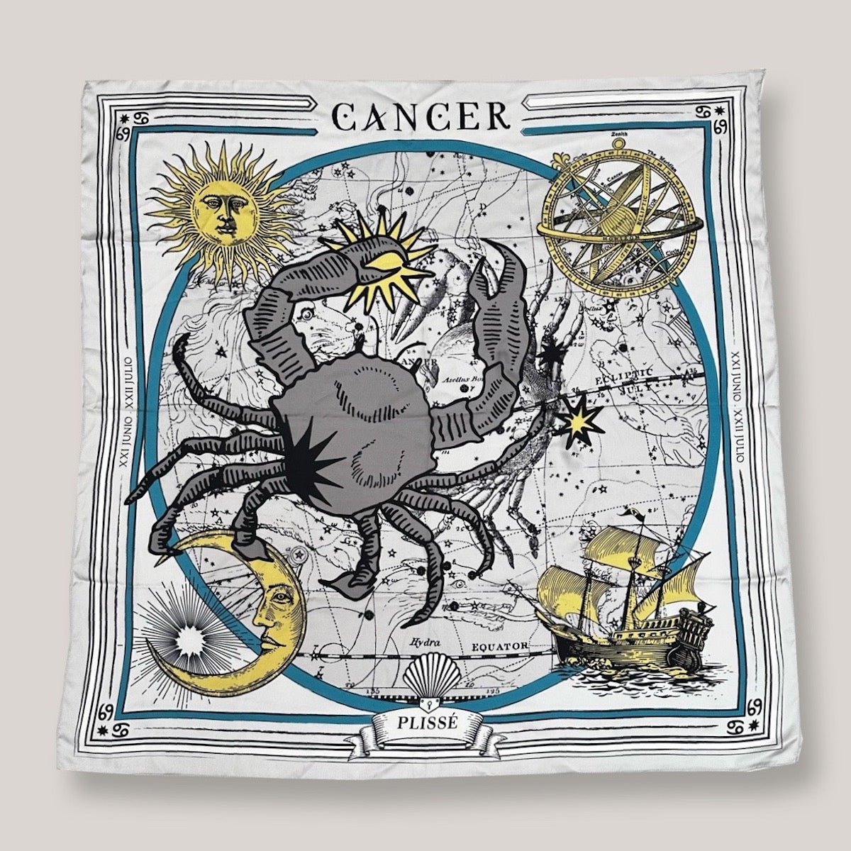 Zodiac scarf for Cancer by Plissé. Off white colored scarf with image of crab, astrological background, sun and moon details. Scarf on plain white background.