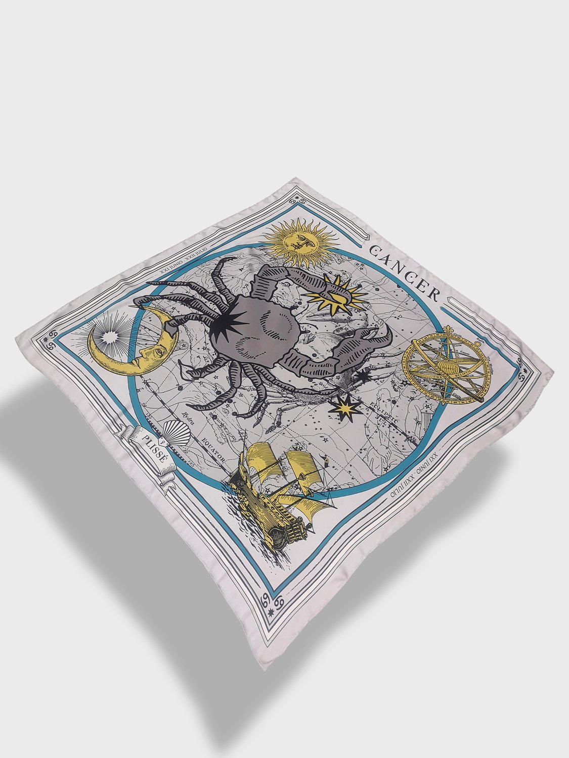 Zodiac scarf for Cancer by Plissé. Off white colored scarf with image of crab, astrological background, sun and moon details. Scarf floating on plain white background.