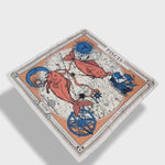 Zodiac Scarf for Pisces made by Plissé. Image of two fish swimming in opposite directions. It is on top of a astrological background. Details of a dark blue ecliptic, sun, moon, and a boat. The scarf is a white with orange and blue details displayed floating on plain background