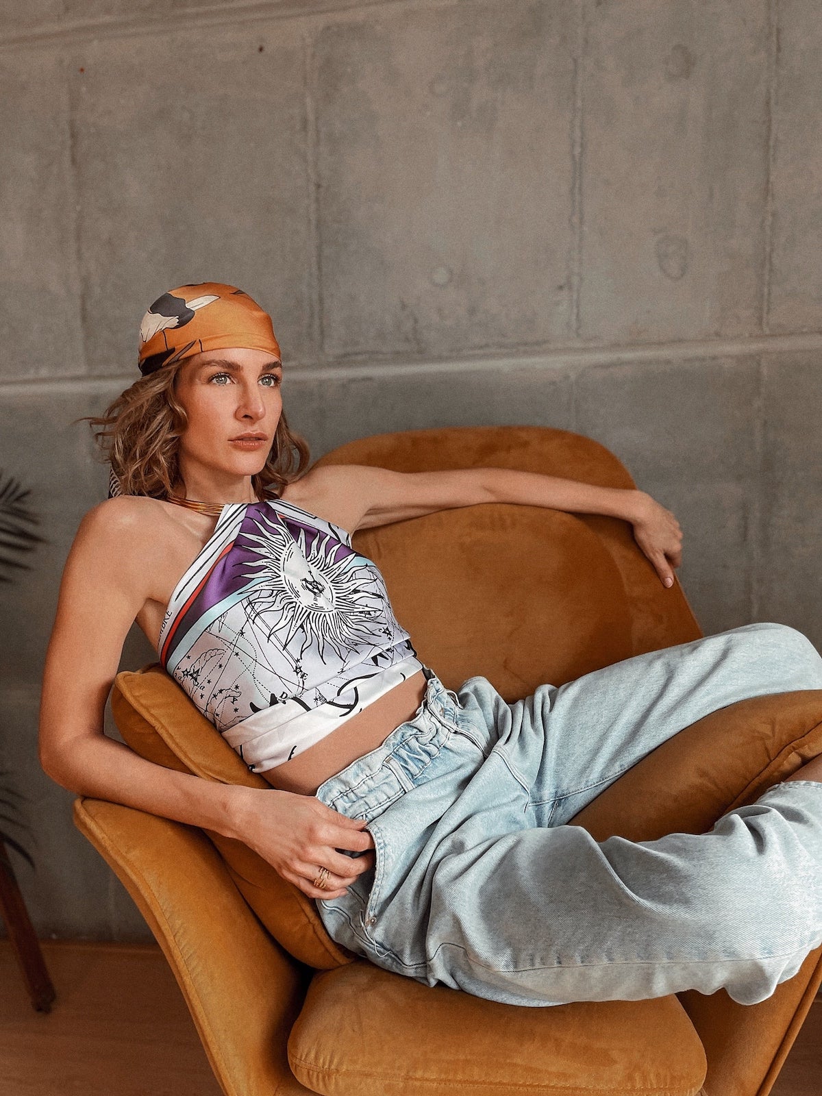 Woman on couch posing with Zodiac Scarf for Sagittarius as a top