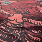 Close up of burgundy scorpio scarf by Plissé. Image of a scorpion, with sun and moon on corners. The scarf is pictured on plain white background.