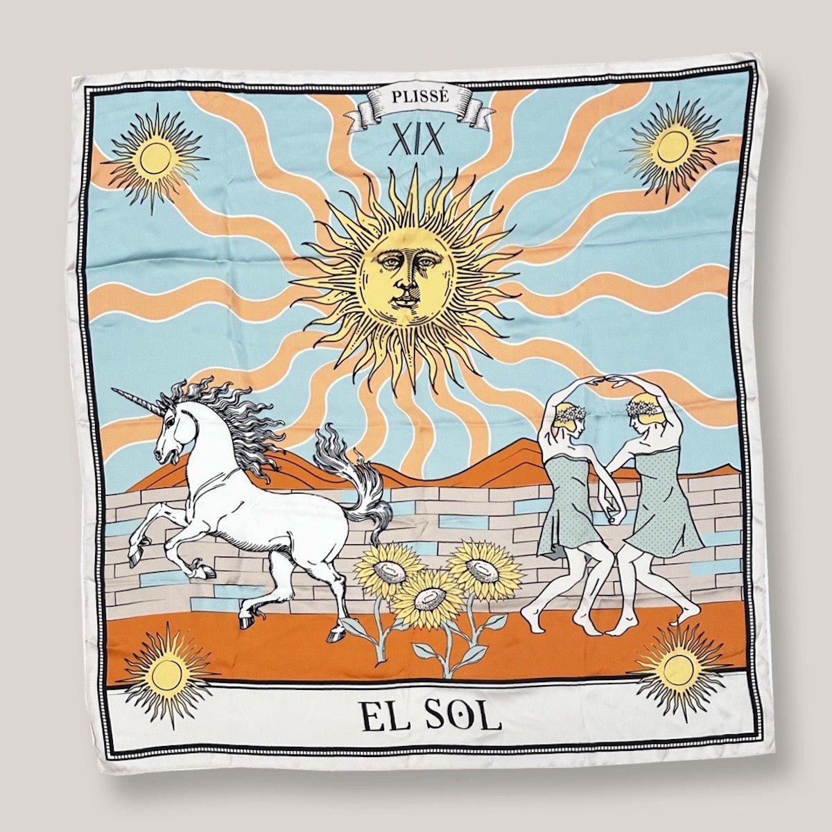 Beautiful sun scarf by Plisse, Image includes sunbursts at each corner, sunflowers in vibrant orange and baby blue tones, and playful elements like a unicorn and dancing figures on plain white background