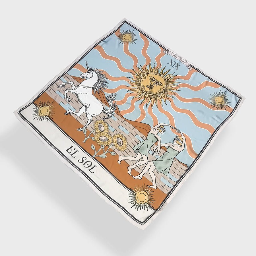 Beautiful sun scarf by Plisse, Image includes sunbursts at each corner, sunflowers in vibrant orange and baby blue tones, and playful elements like a unicorn and dancing figures on plain white background